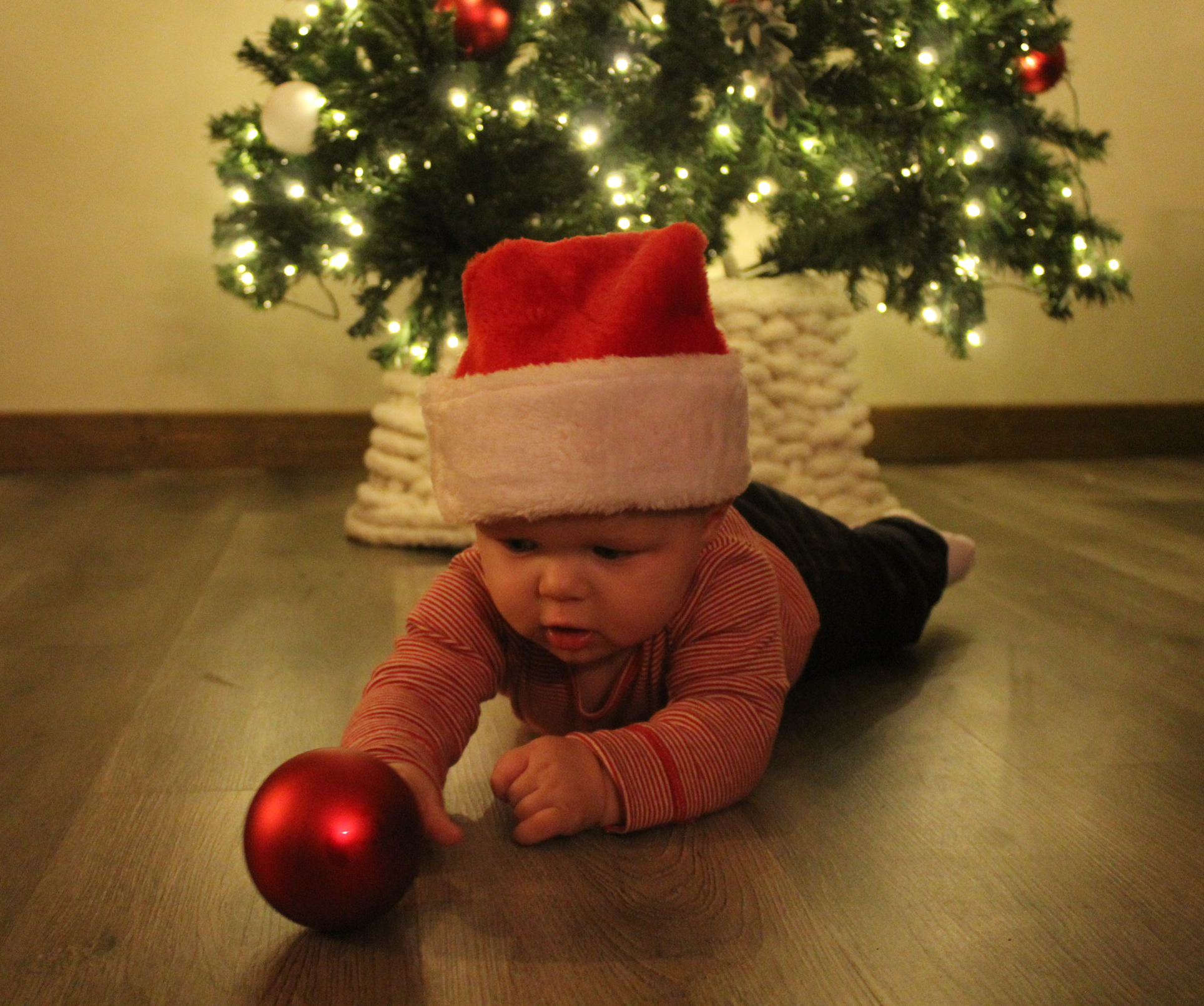 Black and white photo of a woman in a wedding dress in a room in front of a mirror from the back.